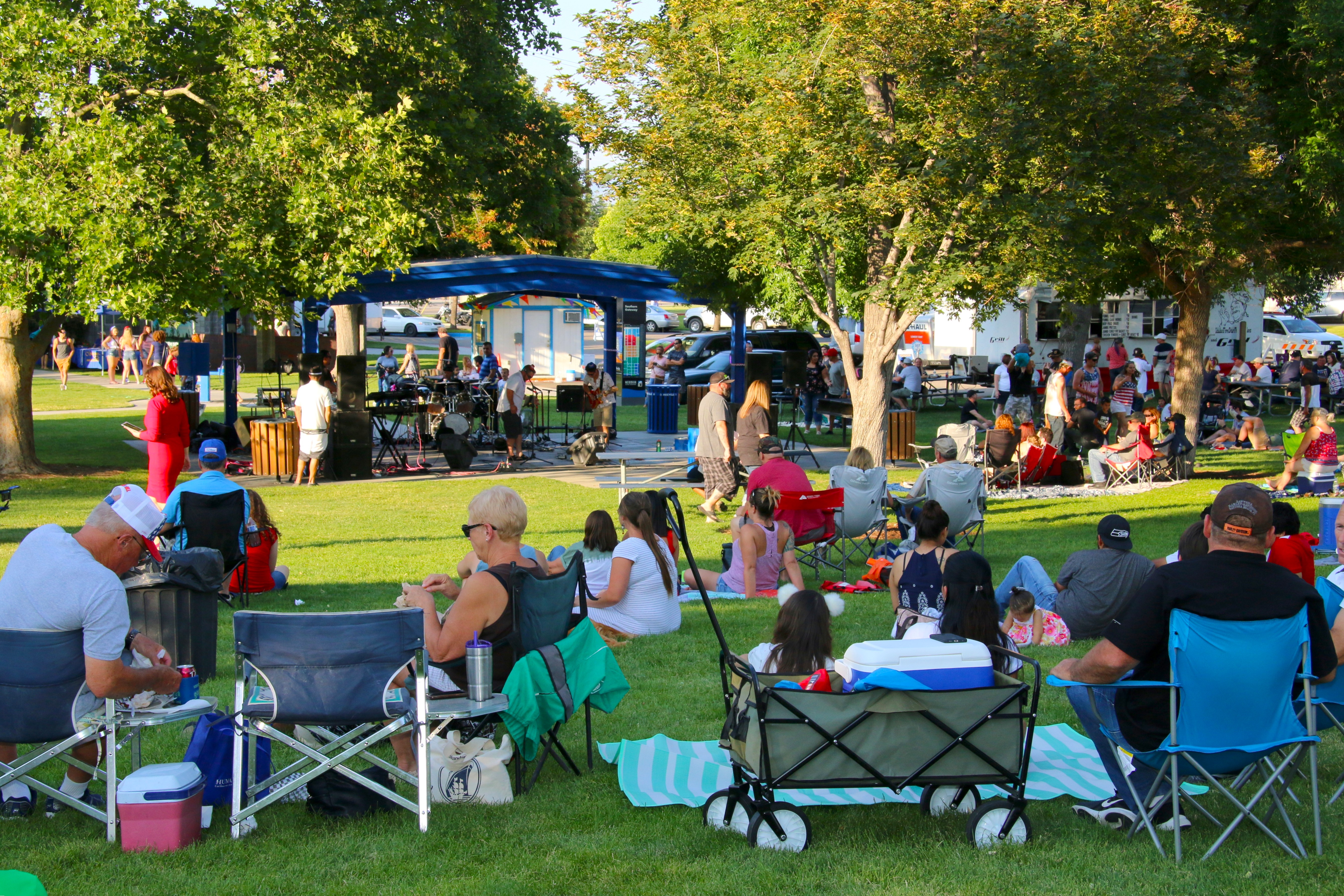 Residents enjoying Storey Park sitting in lawn chairs, on blankets, and listening to live music